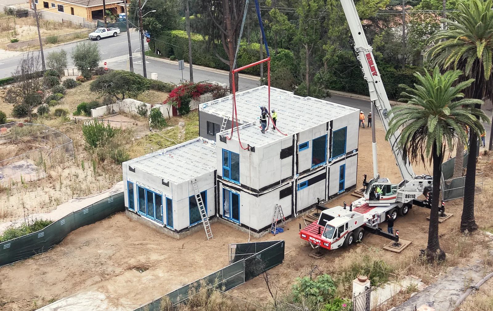 Crane crews assembling full-scale residential modules on a LiveLarge project site